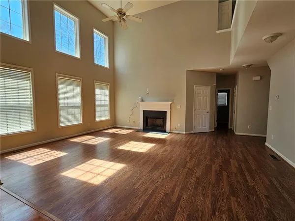 a kitchen with stainless steel appliances granite countertop a refrigerator a sink dishwasher a stove and white countertops with wooden floor