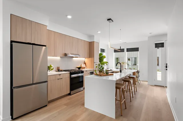 a kitchen with refrigerator a stove a table and chairs