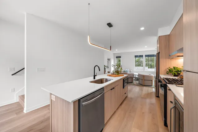 a kitchen with a sink stove and wooden floor