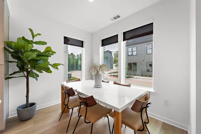 a dining room with furniture and potted plants