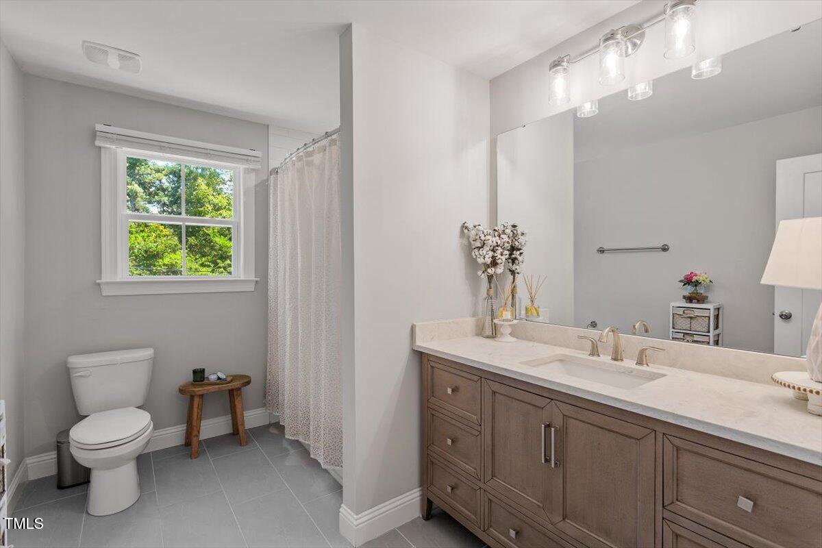 2222 Watkins Street Raleigh, NC 27604 - Photo 13 of 17 a bathroom with a toilet a sink and mirror