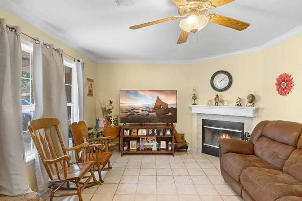 a living room with furniture a fireplace and a flat screen tv