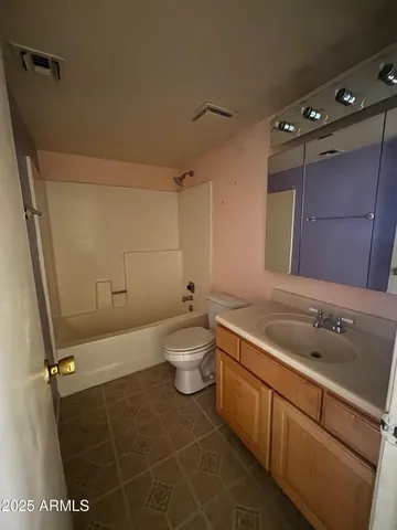 a bathroom with a granite countertop sink a toilet and shower