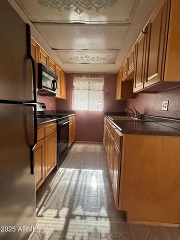 a kitchen with granite countertop stainless steel appliances a stove a sink and a refrigerator