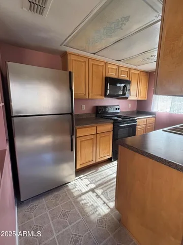 a kitchen with stainless steel appliances granite countertop a refrigerator a stove a sink and a microwave