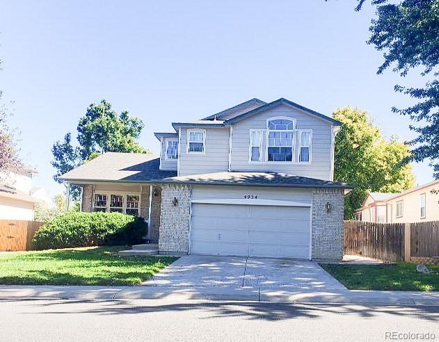 4934 South Danube Street Aurora, CO 80015 - Photo 1 of 22 a front view of a house with a yard and garage