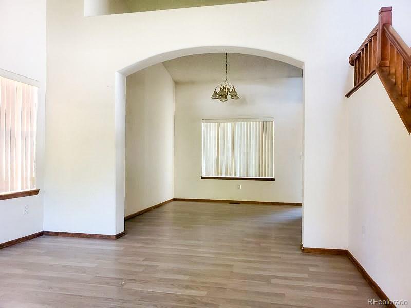 4934 South Danube Street Aurora, CO 80015 - Photo 2 of 22 a view of an empty room with wooden floor and a window