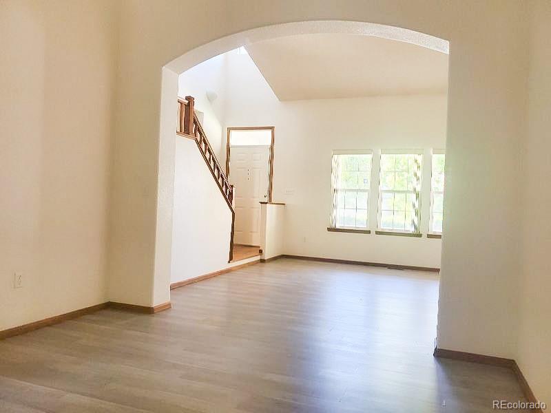 4934 South Danube Street Aurora, CO 80015 - Photo 3 of 22 an empty room with wooden floor and windows