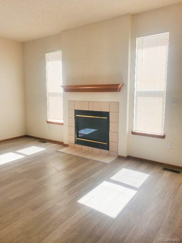 4934 South Danube Street Aurora, CO 80015 - Photo 7 of 22 an empty room with windows and fireplace