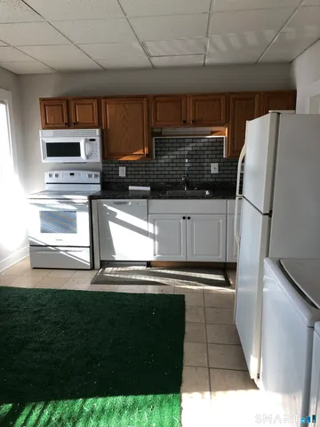 a kitchen with kitchen island a counter top space a sink and cabinets