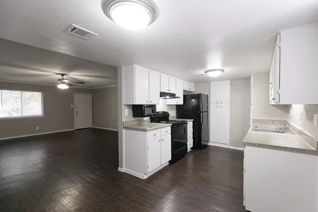 a kitchen with stove cabinets and wooden floor