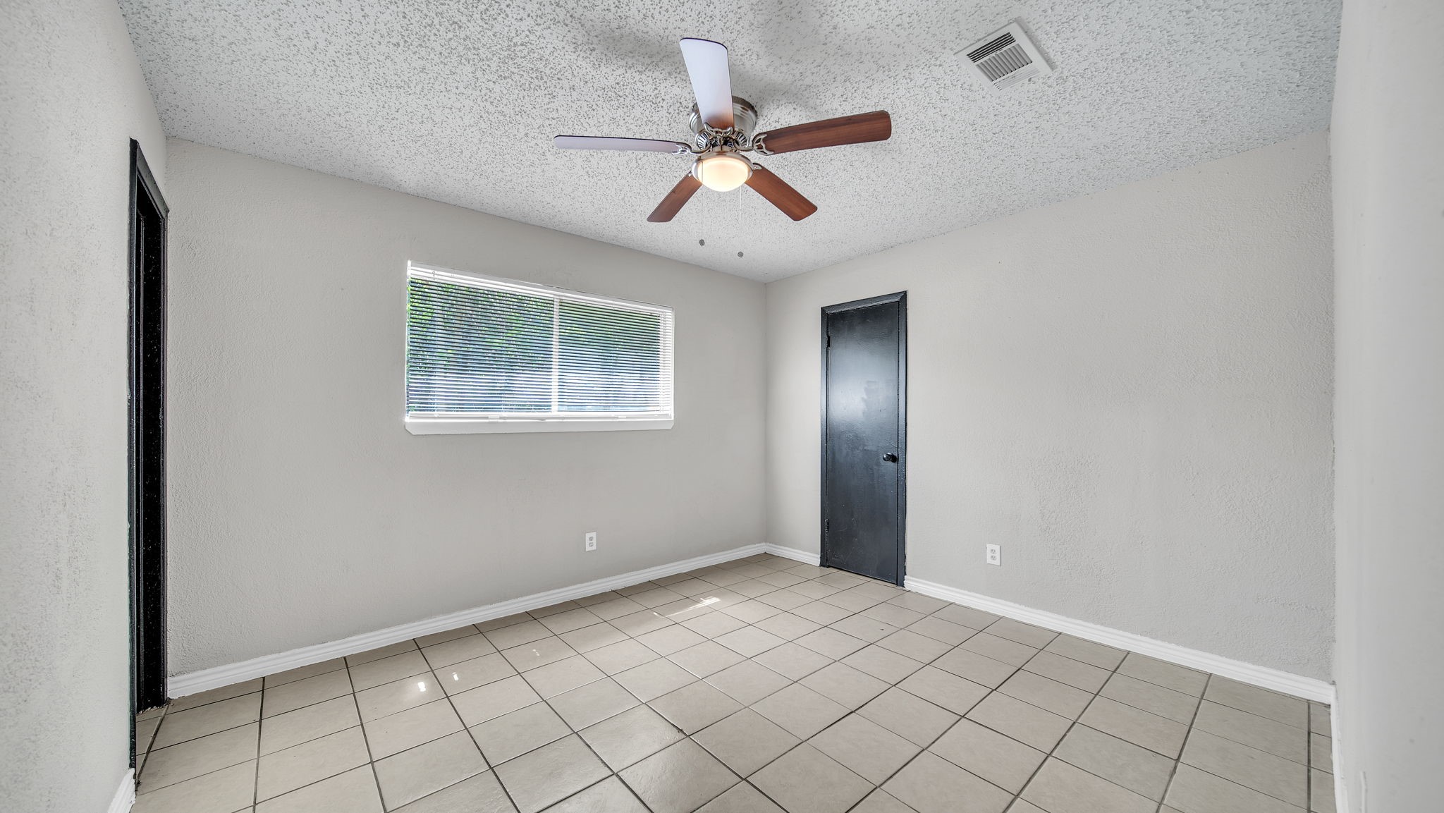 10902 Jutland Road Houston, TX 77048 - Photo 11 of 20 a view of an empty room with a ceiling fan and window