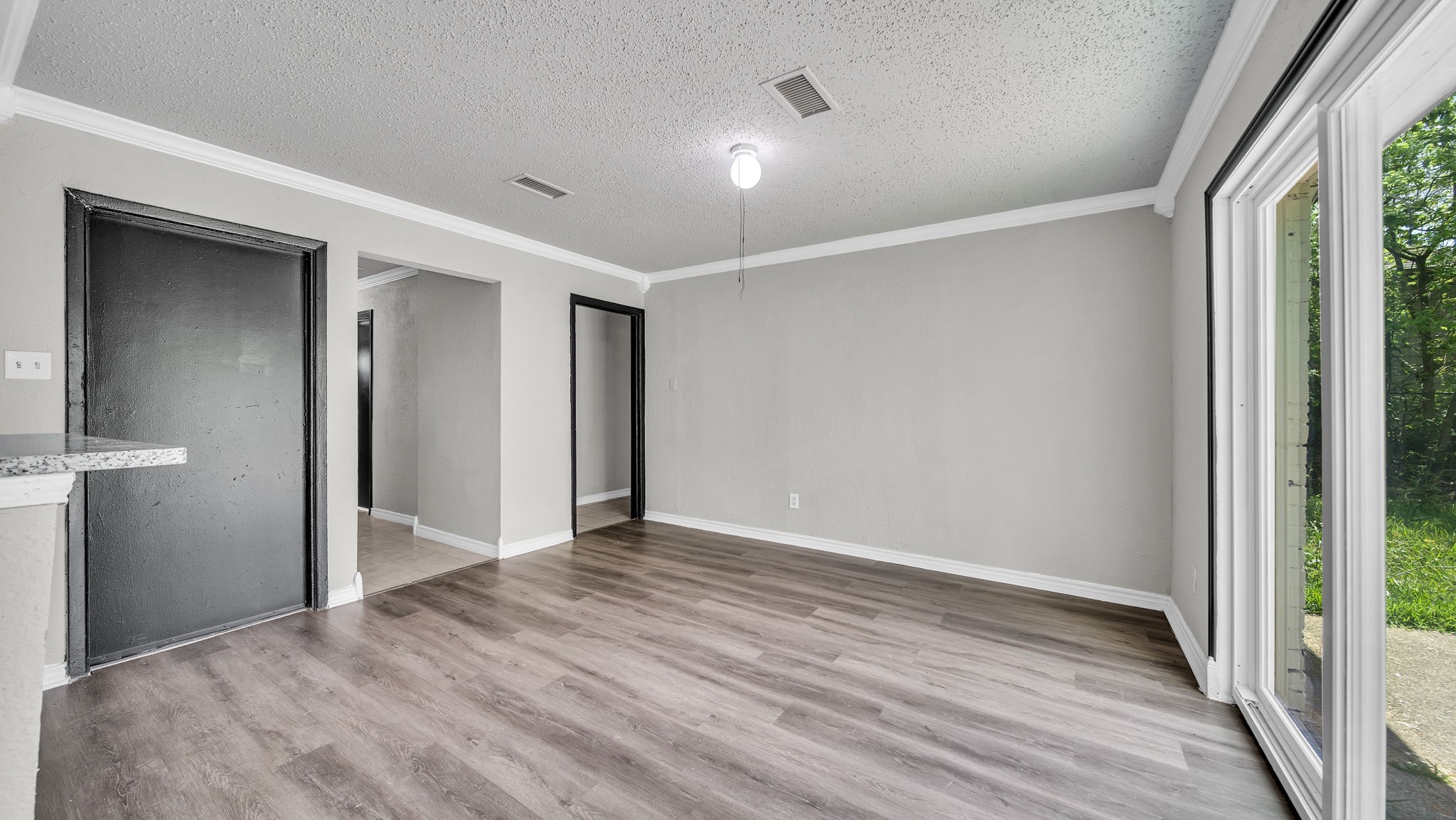10902 Jutland Road Houston, TX 77048 - Photo 9 of 20 a view of an empty room with wooden floor and a window