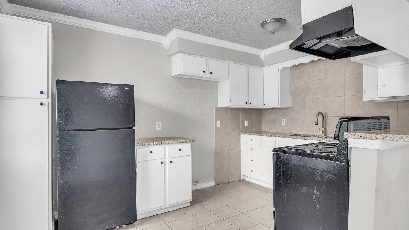 10902 Jutland Road Houston, TX 77048 - Photo 10 of 20 a kitchen with stainless steel appliances a refrigerator a sink and white cabinets