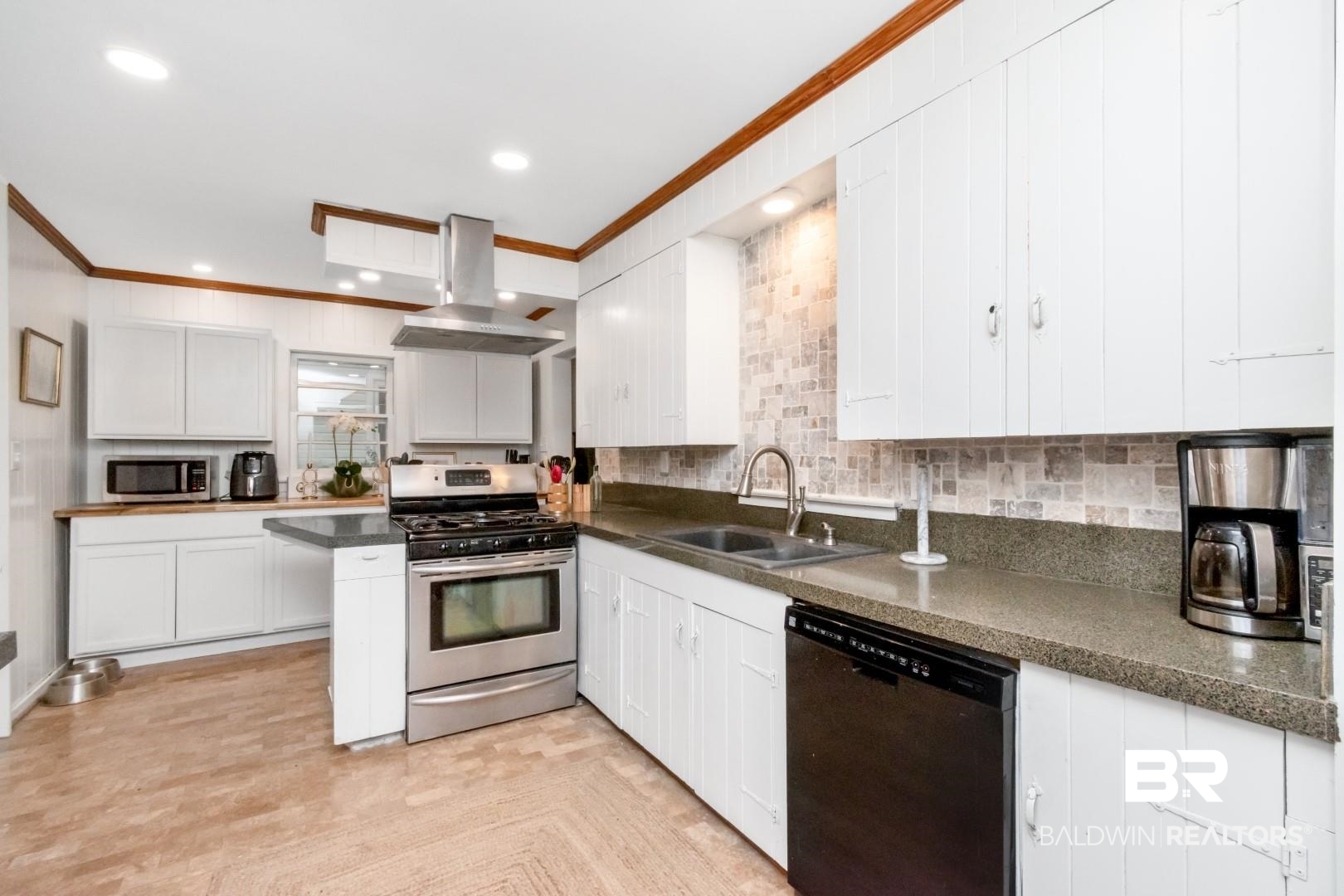 20 Kirby Street Mobile, AL 36607 - Photo 7 of 35 Kitchen with sink, ornamental molding, appliances with stainless steel finishes, island range hood, and white cabinetry