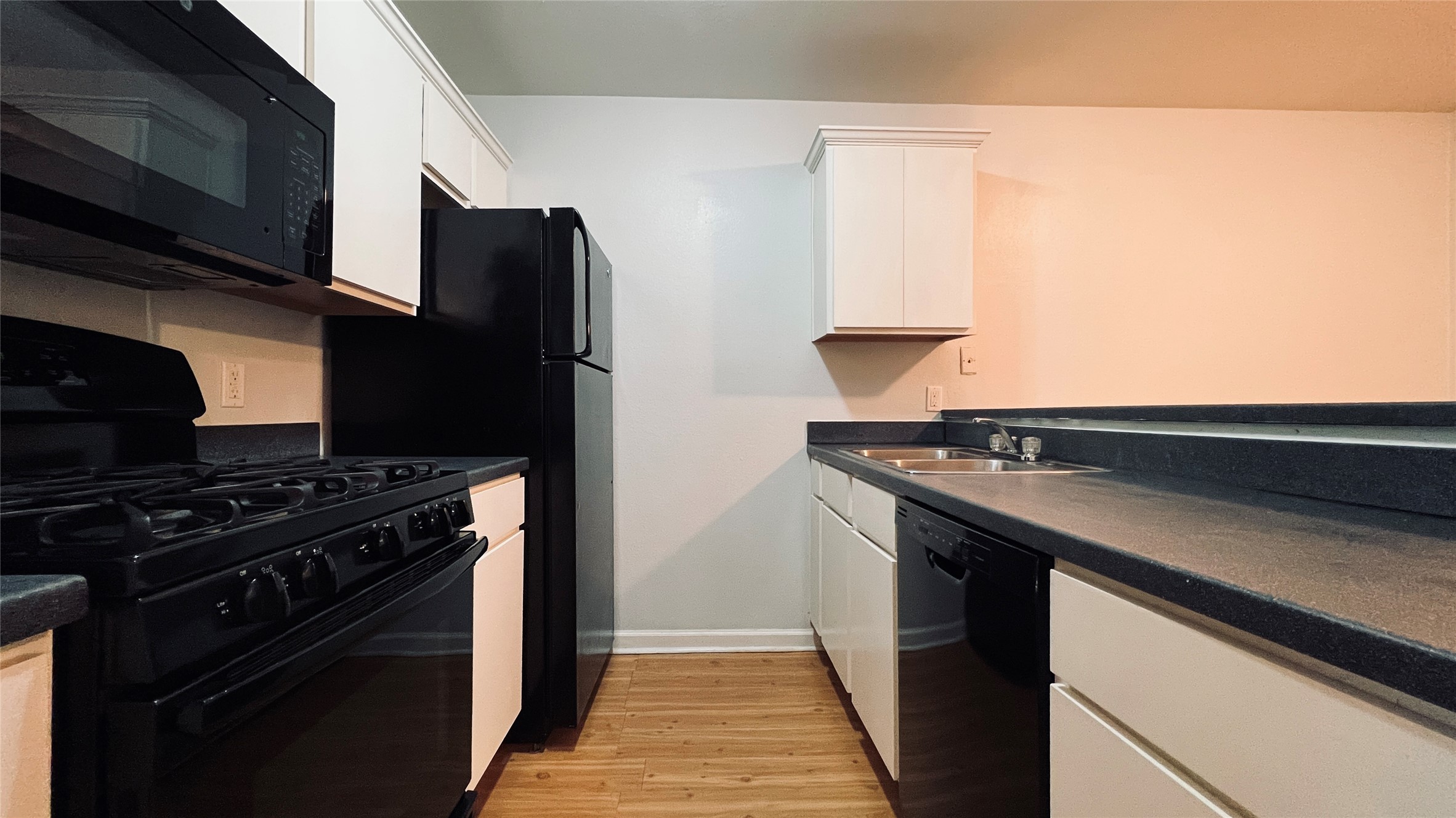 2301 Ohlen Road, Unit 209 Austin, TX 78757 - Photo 3 of 10 Modern kitchen with black appliances offers sleek countertops and ample cabinetry.