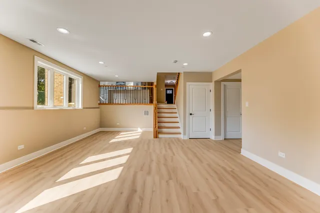 a view of a big room with wooden floor and windows