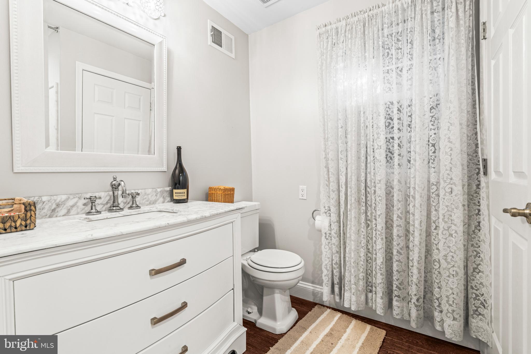 3930 Glenhurst Road Baltimore, MD 21222 - Photo 18 of 29 a bathroom with a granite countertop sink toilet and a mirror