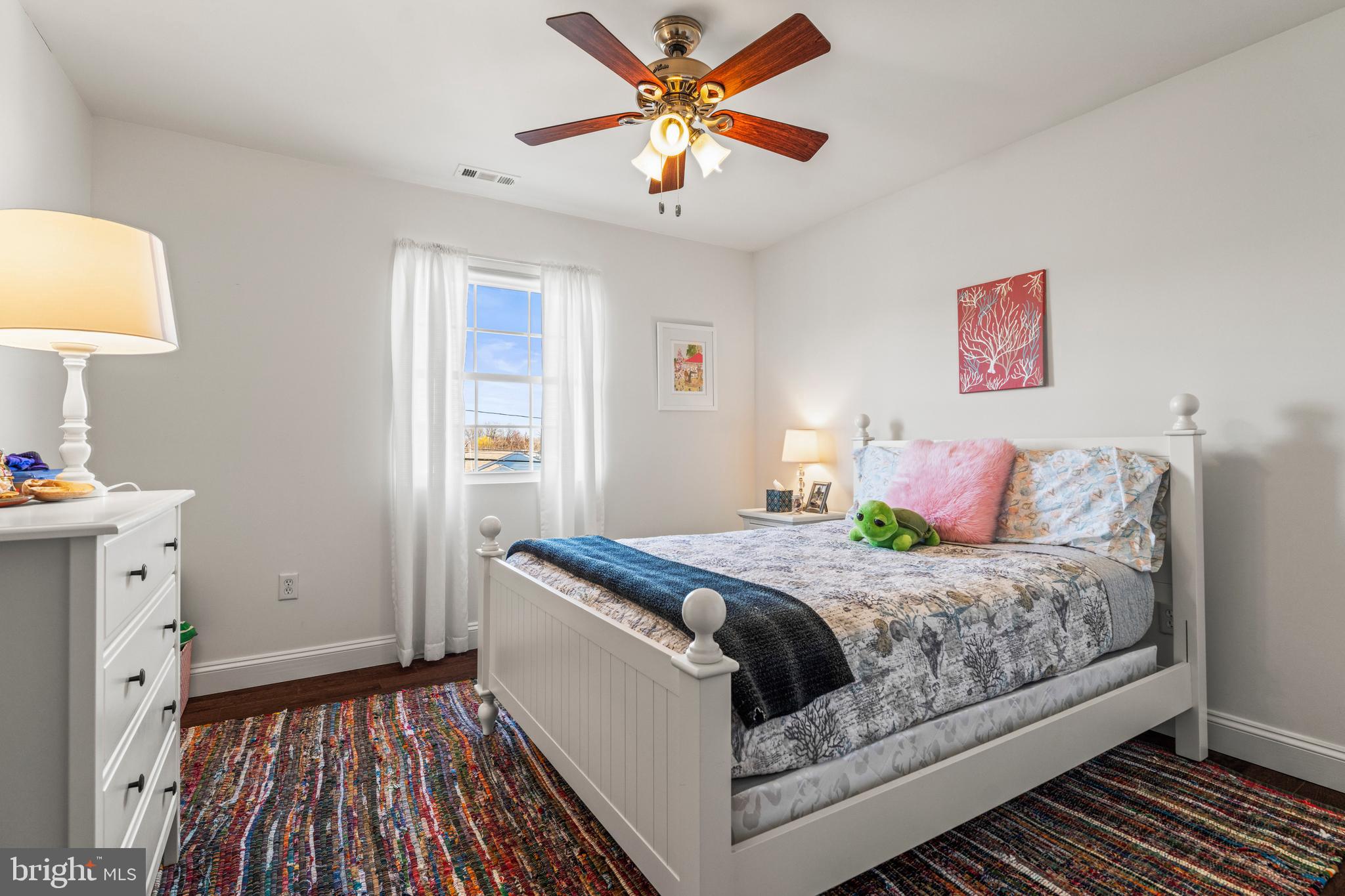 3930 Glenhurst Road Baltimore, MD 21222 - Photo 25 of 29 a bedroom with a bed and a table with wooden floor