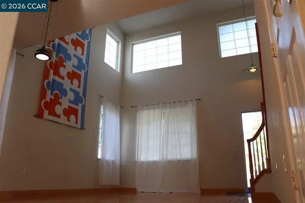 a view of a hallway with windows and chandelier