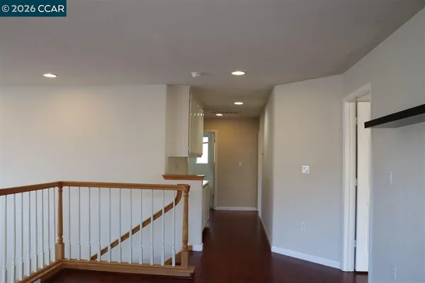 a view of a hallway with wooden floor and staircase