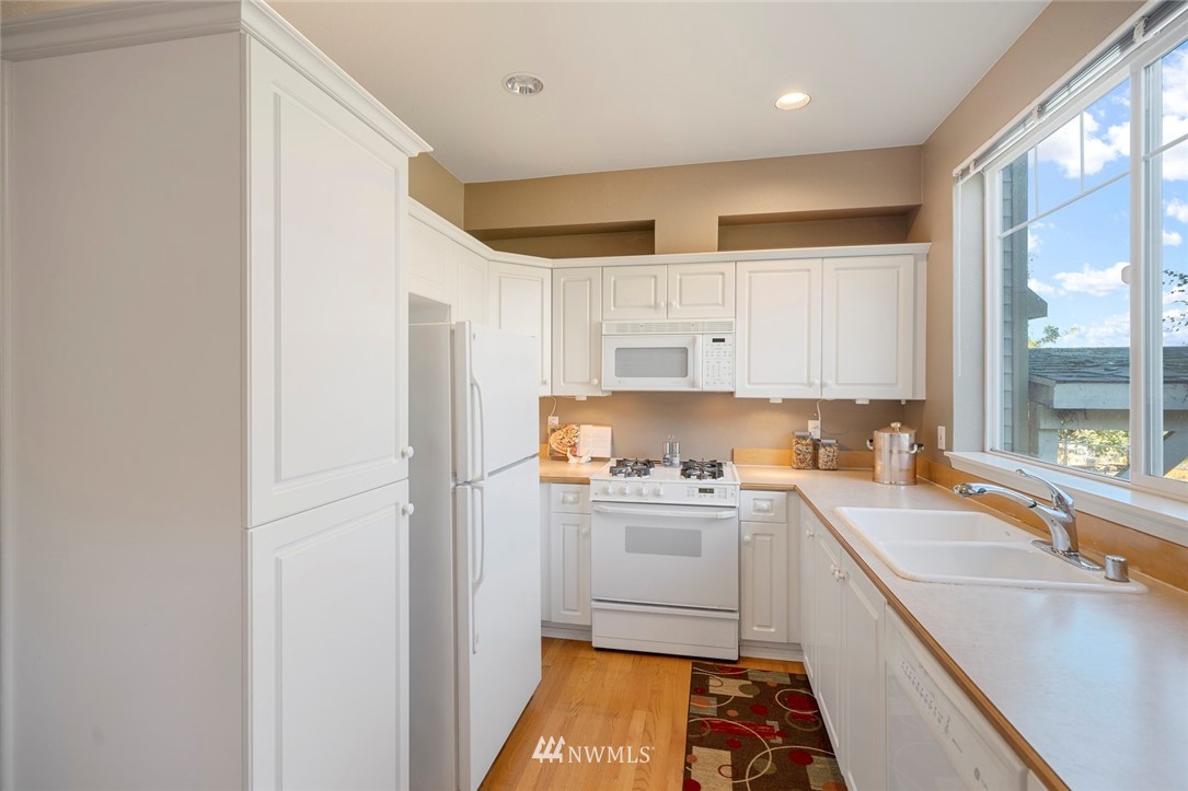 516 South 46th Place, Unit 516 Renton, WA 98055 - Photo 11 of 25 a kitchen with a sink stove and refrigerator