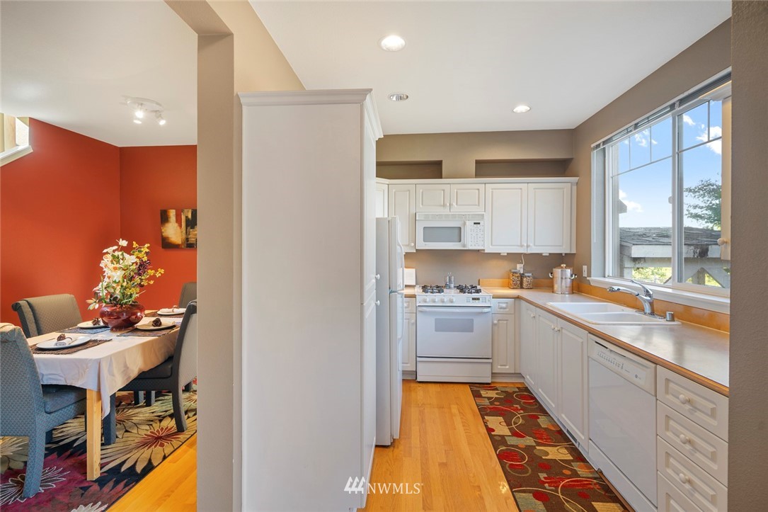 516 South 46th Place, Unit 516 Renton, WA 98055 - Photo 10 of 25 a kitchen with granite countertop kitchen island stainless steel appliances a sink and counter space