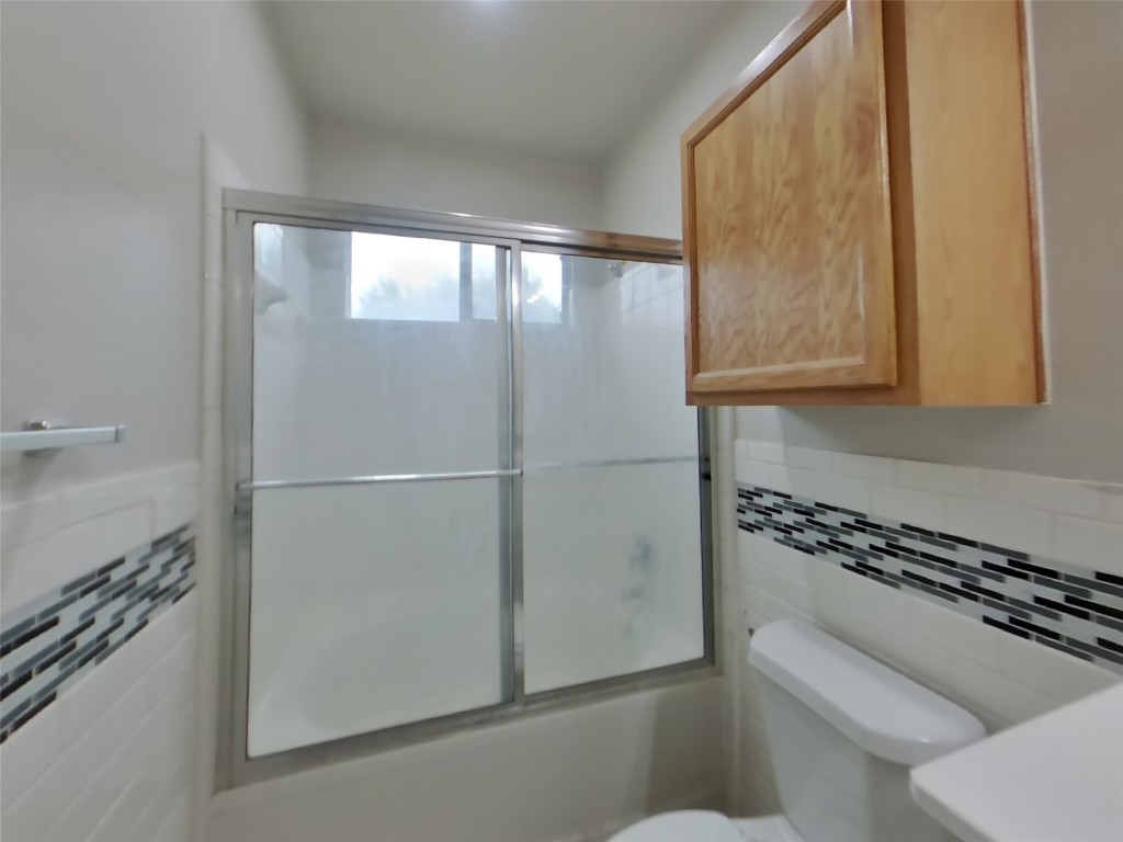 11602 Morgan's Point Street Manor, TX 78653 - Photo 11 of 17 a bathroom with a toilet a sink and a window