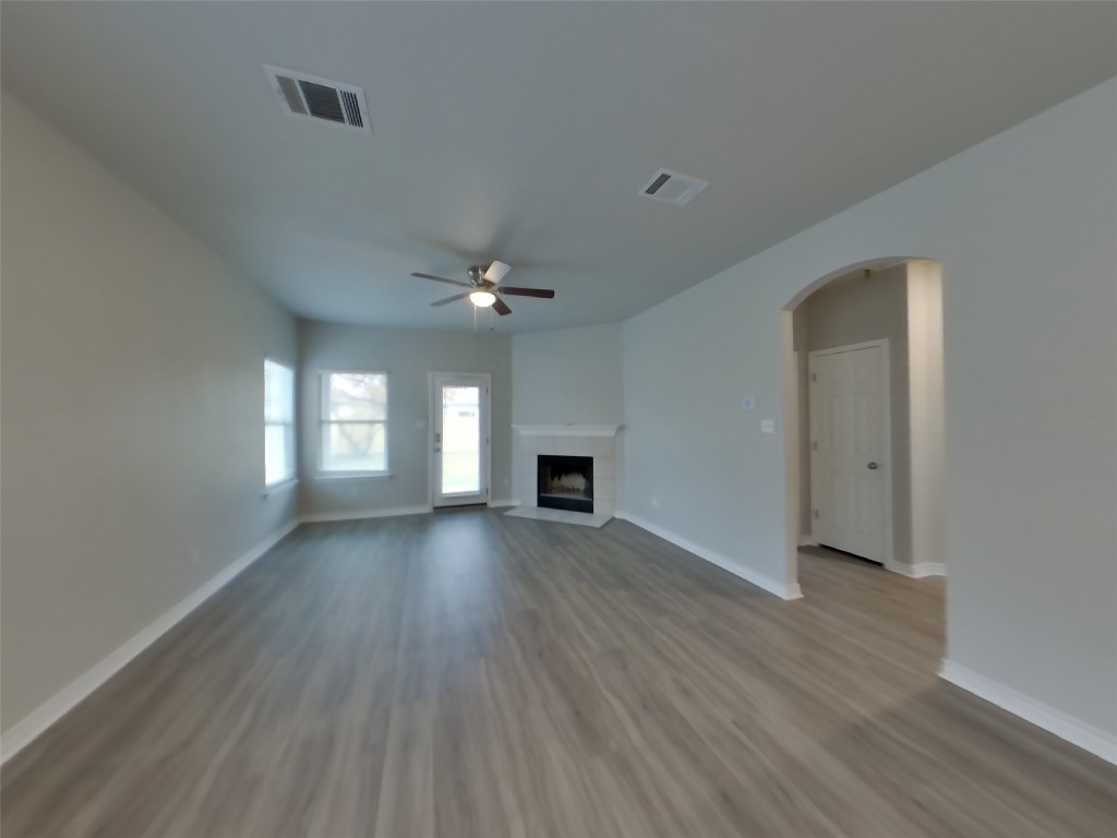 11602 Morgan's Point Street Manor, TX 78653 - Photo 3 of 17 an empty room with wooden floor and fireplace