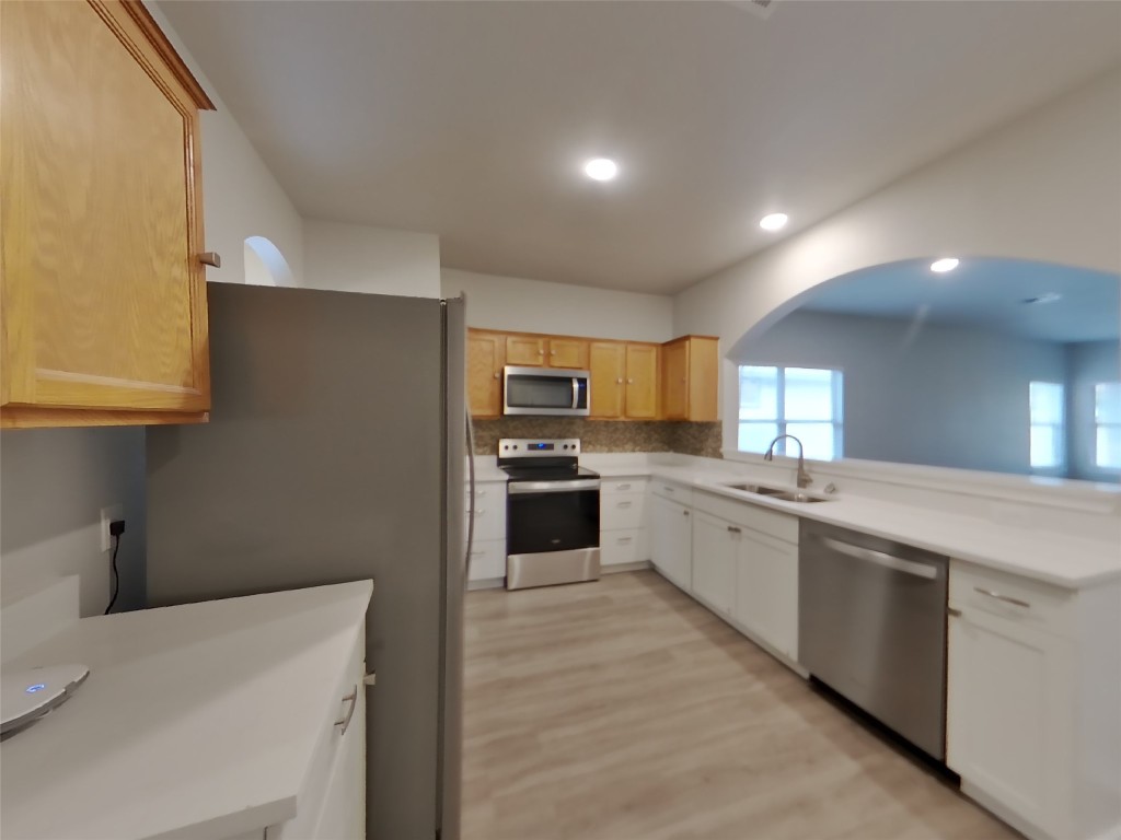 11602 Morgan's Point Street Manor, TX 78653 - Photo 6 of 17 a large kitchen with a large counter top space a sink stainless steel appliances and cabinets