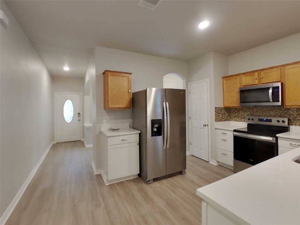 11602 Morgan's Point Street Manor, TX 78653 - Photo 7 of 17 a kitchen with a refrigerator and a stove top oven