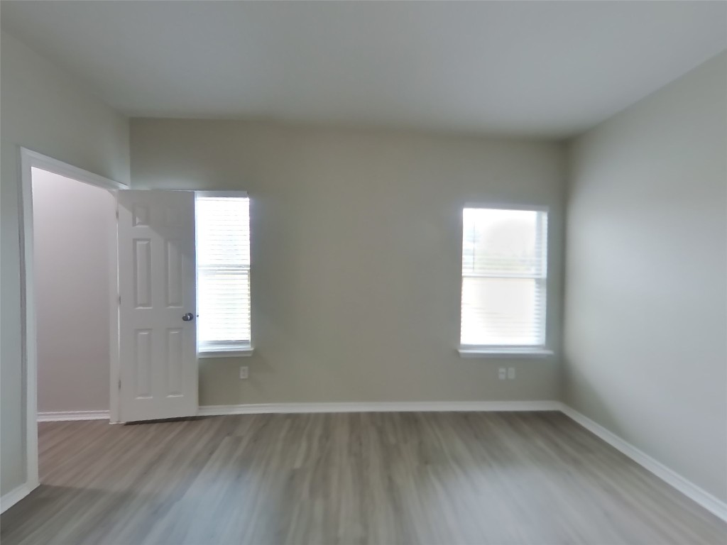 11602 Morgan's Point Street Manor, TX 78653 - Photo 8 of 17 an empty room with wooden floor and windows