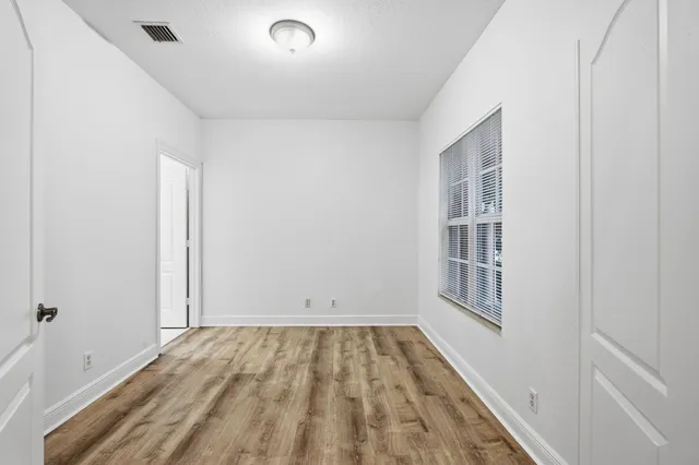 wooden floor in an empty room with a window