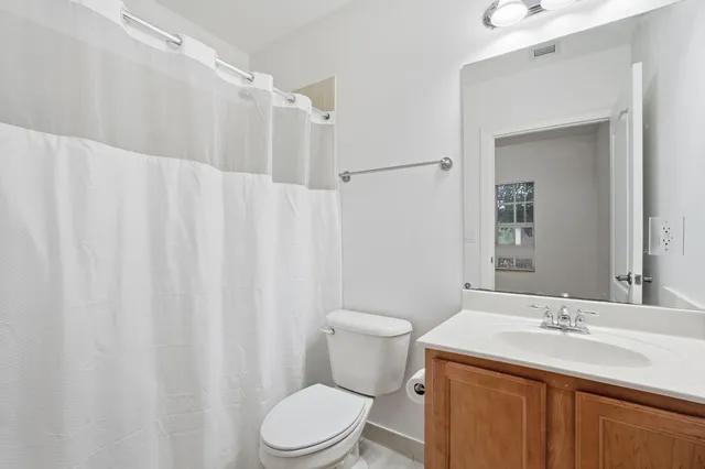 a bathroom with a toilet a sink and a mirror