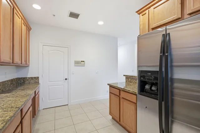 a kitchen with stainless steel appliances granite countertop a refrigerator and a stove