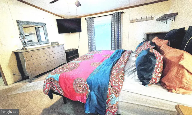 a bedroom with a large bed and a flat tv screen on dresser