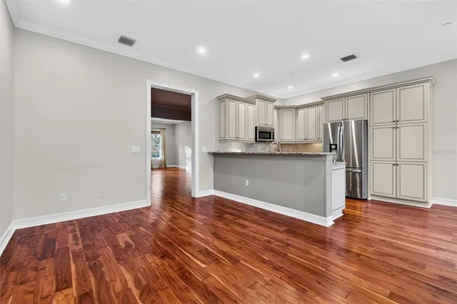 a view of empty room with wooden floor and fan