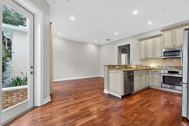 a kitchen with stainless steel appliances granite countertop a refrigerator microwave and sink