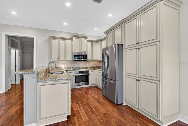 a kitchen with stainless steel appliances granite countertop a sink stove and microwave