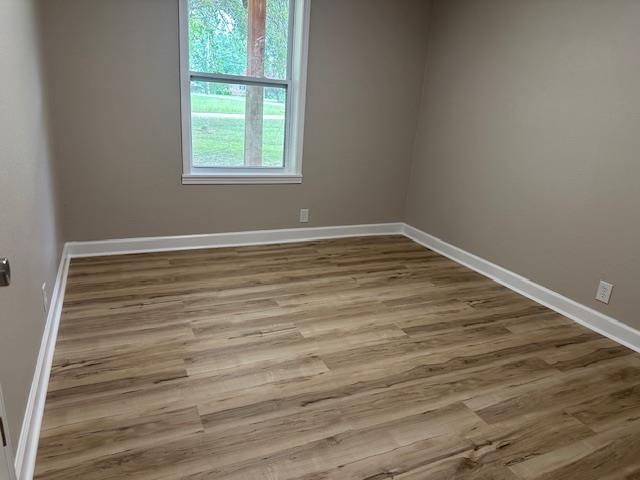 15 Brookwood Loop Adamsville, TN 38310 - Photo 7 of 21 a view of an empty room with wooden floor and a window