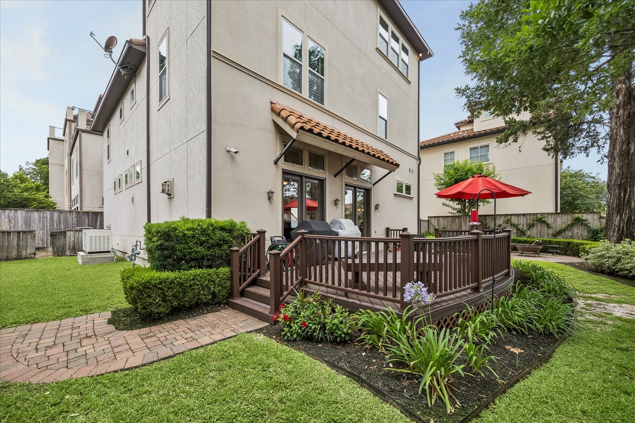 907 Queen Annes Road Houston, TX 77024 - Photo 24 of 31 Rare outdoor green space featuring a low-maintenance composite deck, landscaped yard, and seamless access from the main living areas—ideal for entertaining and everyday enjoyment.