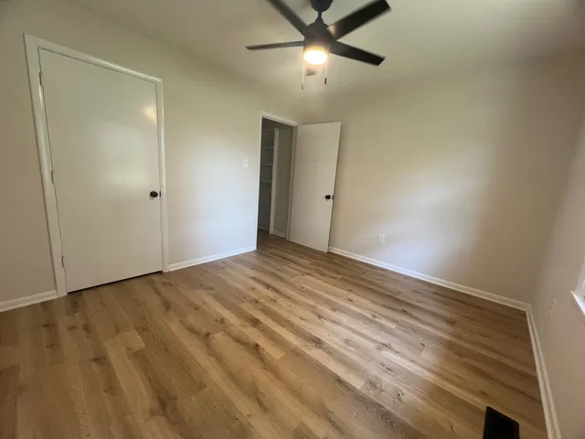 a view of an empty room and chandelier fan