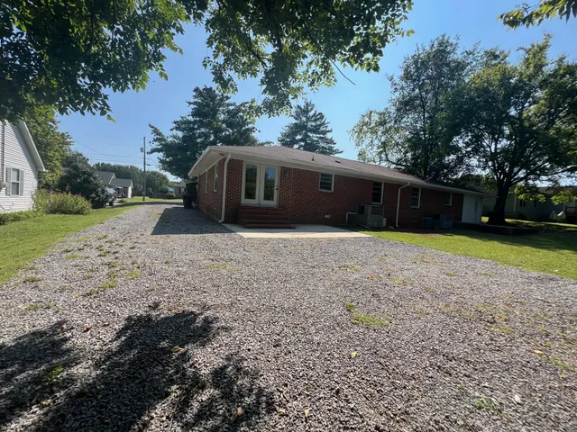 a front view of a house with a yard and trees