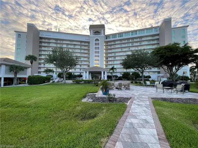 a front view of a building with outdoor seating and green space