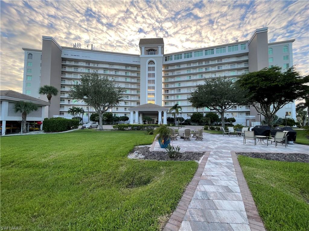 a front view of a building with outdoor seating and green space