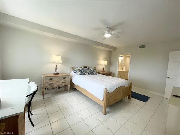 a bedroom with a bed and a lamp on desk