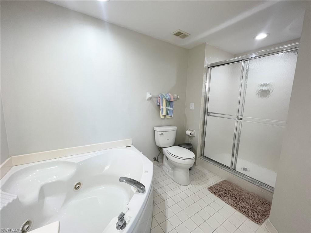 13105 Vanderbilt Drive, Unit 802 Naples, FL 34110 - Photo 14 of 32 a bathroom with a bathtub and a toilet
