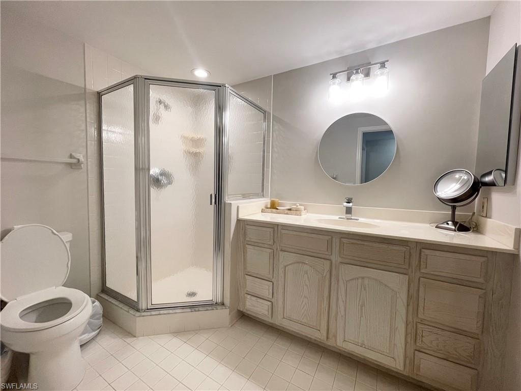 13105 Vanderbilt Drive, Unit 802 Naples, FL 34110 - Photo 15 of 32 a bathroom with a toilet sink and mirror