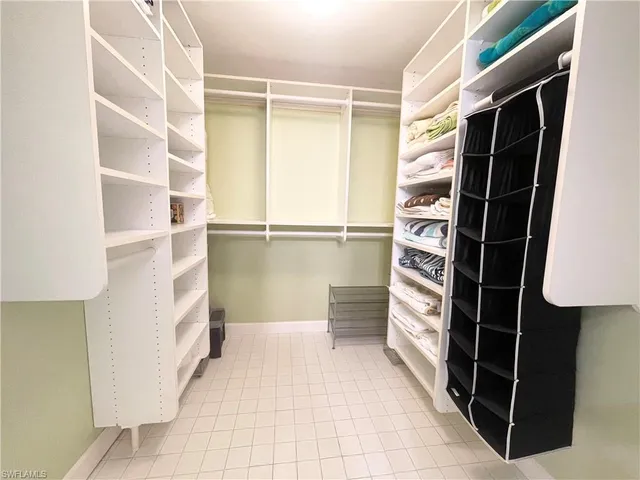 a view of walk in closet with clothes and shoes