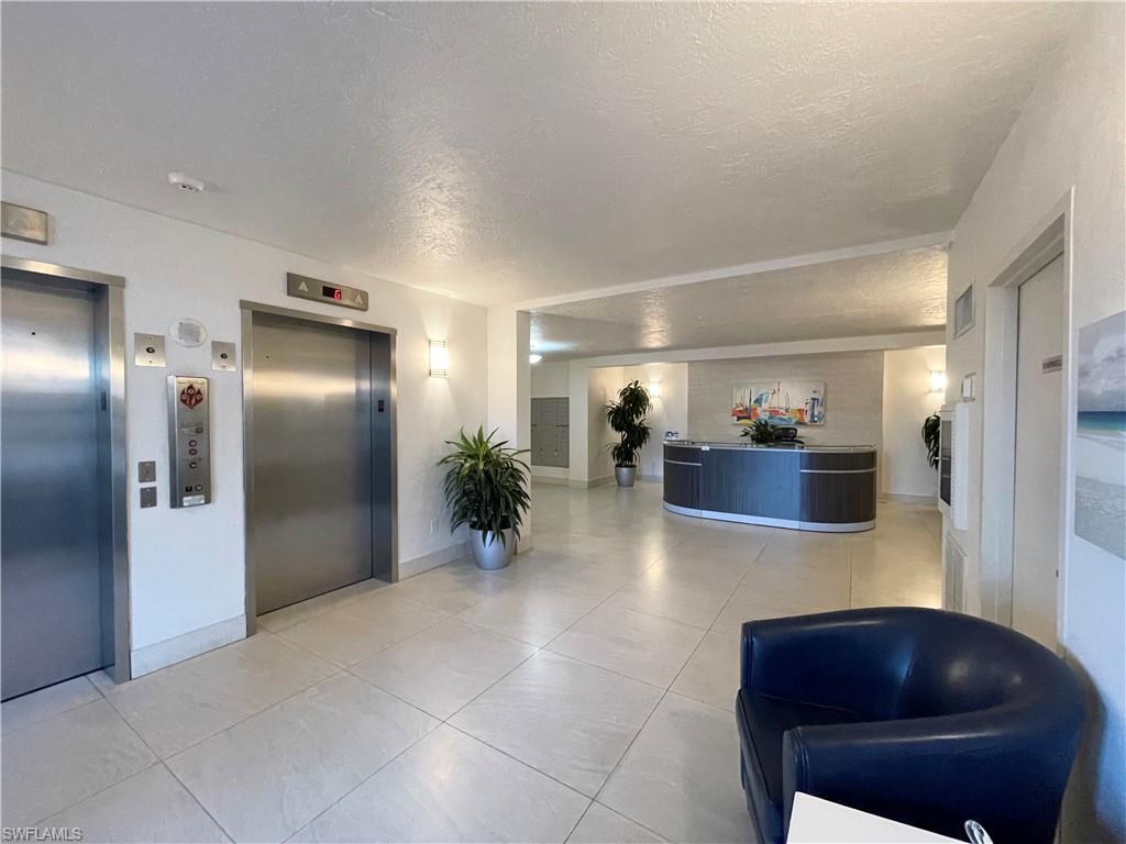 13105 Vanderbilt Drive, Unit 802 Naples, FL 34110 - Photo 20 of 32 a lobby with furniture and potted plant